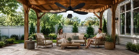 Black solar ceiling fan with light installed over covered patio seating area