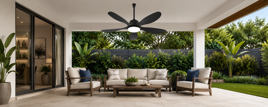 Black ceiling fan with light mounted above seating in a covered outdoor living area