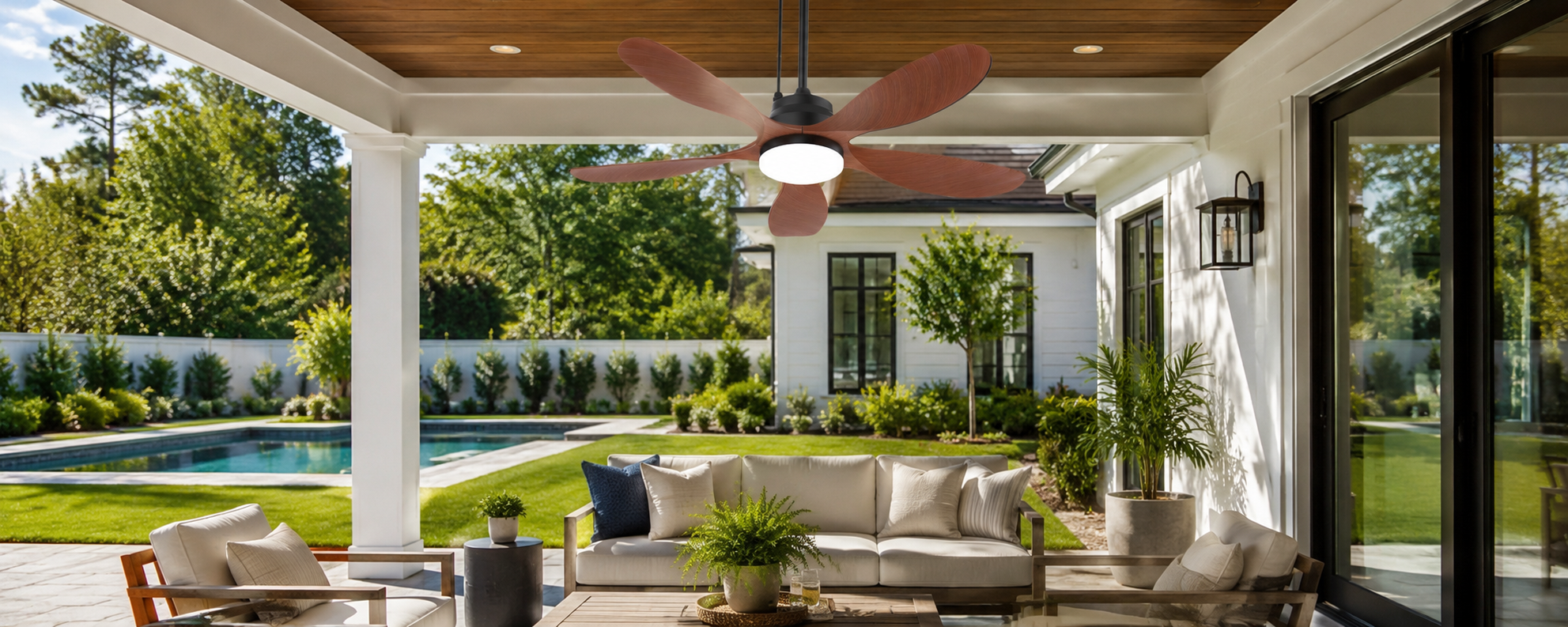 Ventallion solar ceiling fan with LED light over a covered patio dining area after sunset