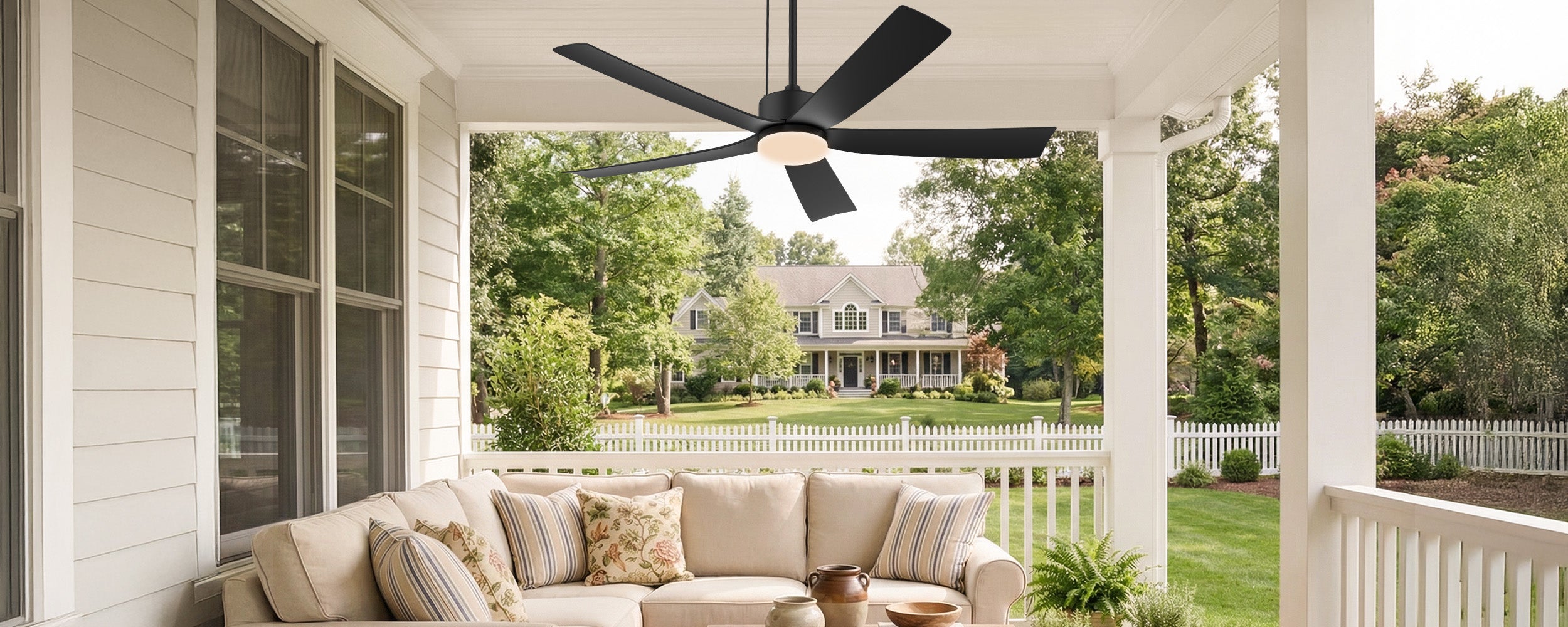 covered porch seating area with a black outdoor ceiling fan installed overhead