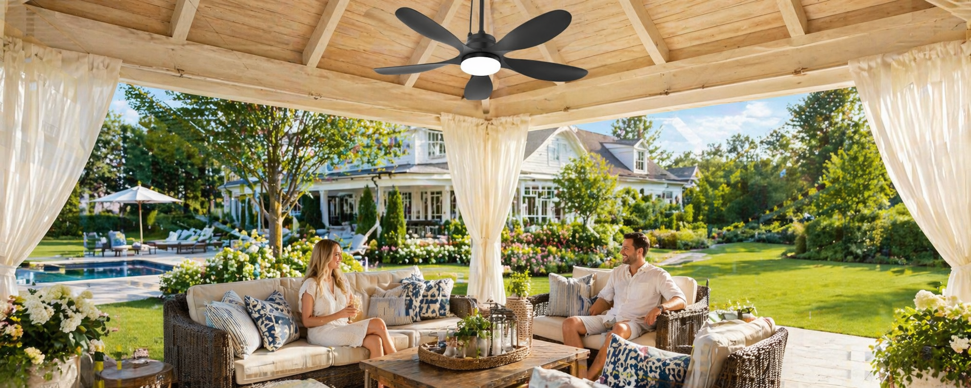 Outdoor solar ceiling fan installed above a covered pergola seating area